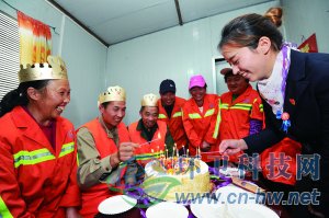 社區(qū)工作人員為集體過生日的三名環(huán)衛(wèi)工人點上生日蠟燭。 本報通訊員 趙松 攝